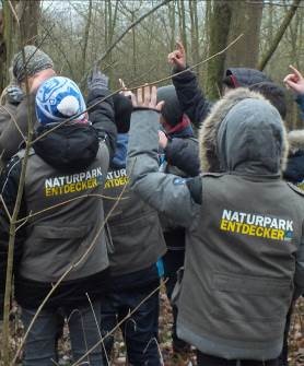 Kinder mit Entdeckerwesten medlen sich bei einer Bildungsaktion mit den Naturpark Ranger